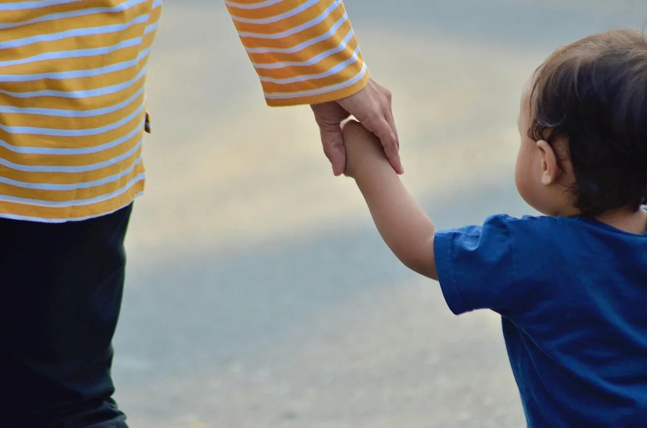 mother holding young child's hand